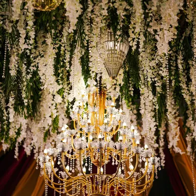 A magnificent crystal and floral chandelier, serving as a grand centerpiece and bathing the event in warm, elegant light.
