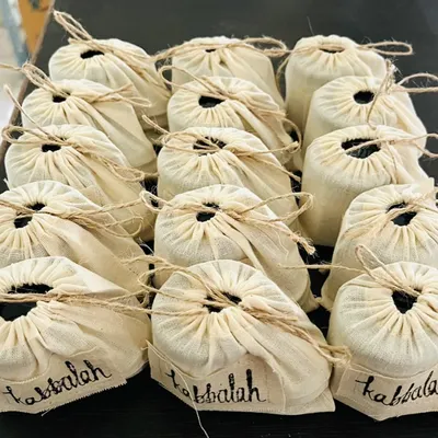 Preparing a corporate gift order. These full-sized body creams and polishers are packed in reusable muslin bags, making a thoughtful and sustainable gift for any team.
