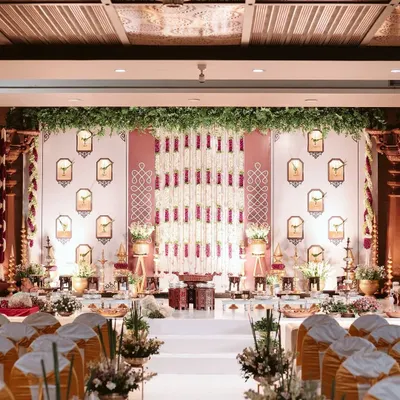 A grand yet intimate engagement stage setup. We used traditional elements like floral tuberose strings and parrot motifs in wall niches to create a backdrop that is rich in South Indian culture and symbolism.