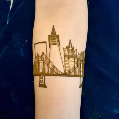The start of a custom San Francisco skyline design. This is the initial outline of the Golden Gate Bridge and city buildings on the forearm.
