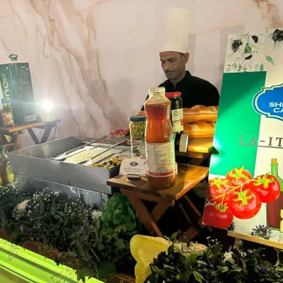 Our chef at the 'La Italia' station, preparing for a busy service. The counter is stocked with authentic ingredients, showcasing our readiness to serve fresh, made-to-order Italian food at a wedding.