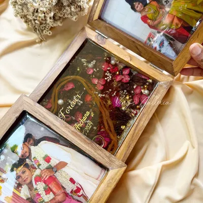 Some memories deserve more than just a photo. This folding frame tells a story, with the center panel preserving the varmala, mangalsutra thali, and toe rings, flanked by two beautiful photos of the couple.