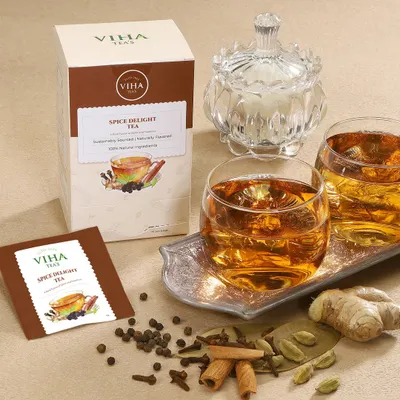 A warm, inviting lifestyle scene for a spice delight tea, showcasing the packaging alongside a prepared cup and the raw spices used in the blend.