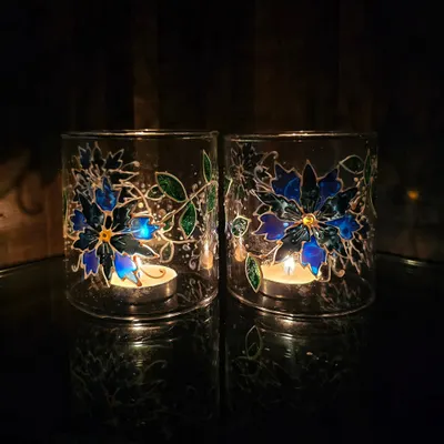 The magic happens when you light a candle inside. These lamp chimneys, painted with blue flowers, create a beautiful, glowing effect that's perfect for festive evenings.