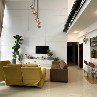 This penthouse living room is the definition of minimalist luxury. I used a clean white palette, comfortable sofas, and a stunning cascading chandelier to make the double-height space feel grand yet inviting.