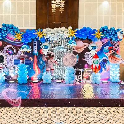 I transformed this hall into an entire galaxy for a 5th birthday. This space adventure theme features a custom-printed backdrop with planets and stars, astronaut cutouts, rocket ships, and even themed flooring to complete the immersive experience.