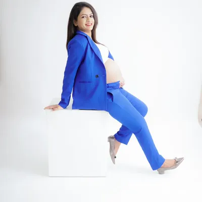 A powerful and chic "boss mama" look. This portrait features a stylish royal blue suit, showing that pregnancy is a time of strength and confidence.
