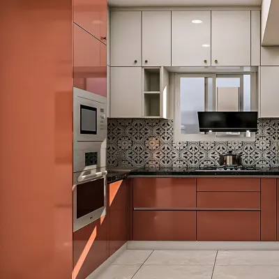 This L-shaped modular kitchen features a bold combination of glossy rust-orange and white cabinets. The patterned tile backsplash adds a decorative touch, while the built-in oven and microwave unit ensures a seamless and modern look.