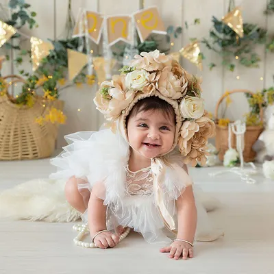 This large, cream-colored floral bonnet is a beautiful statement piece that instantly elevates a portrait. It's soft, easy to place on a baby, and photographs wonderfully.