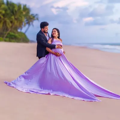 A beautiful portrait of togetherness on the beach. The mom-to-be wears our flowing lavender infinity gown, while her partner looks sharp in a classic black suit, creating a perfectly balanced and elegant couple's maternity photo.