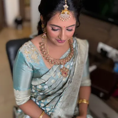 The beautiful Jahnavi for her son's naming ceremony. We created a minimalist look with soft pink eyeshadow and a neat updo, perfect for a daytime family event.
