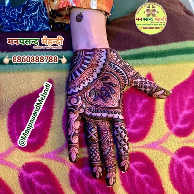 A classic Arabic mehndi design. The pattern flows diagonally across the hand, featuring bold outlines and delicate shading for a beautiful, modern look.