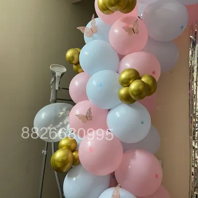 This is a close-up of a balloon garland I created for a baby shower. The soft pink, blue, and white balloons are accented with small gold balloons and delicate paper butterflies for a sweet touch.