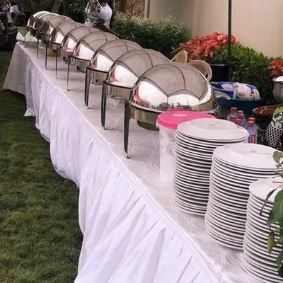 Our classic buffet setup is perfect for any large gathering or wedding. We provide everything from chafing dishes to keep food warm, clean table skirting, and stacks of plates, ensuring a professional and seamless dining experience for your guests.