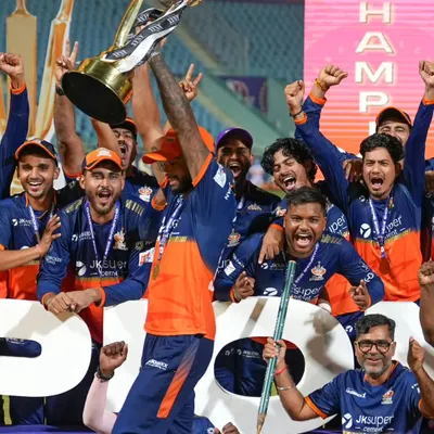 The peak of celebration as the Kashi Rudras hoist their UPT20 League championship trophy. I position myself to capture the collective joy of the team in this defining moment.