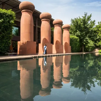 The grand pillars of The Roseate stand reflected in the calm water, a signature feature of our resort's architecture. This is the view that greets you, promising peace and luxury.