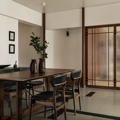 The dining area in Apartment 1005 features an assortment of custom hardwood pieces, including a sturdy dining table and chairs. The space is defined by a unique 'Tetris' floor pattern using grey Kota stone and black granite inlays.