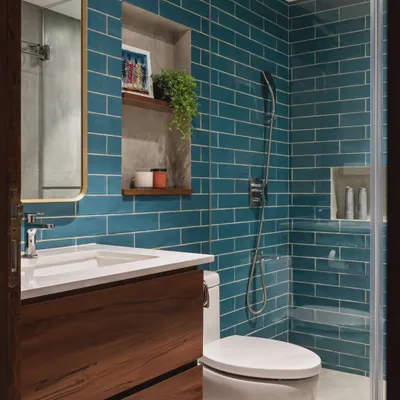 This bathroom shows how a simple switch of tile color can transform a space. The vibrant teal subway tiles create a fresh and energetic vibe, beautifully complemented by the warm wood vanity and brass mirror frame.