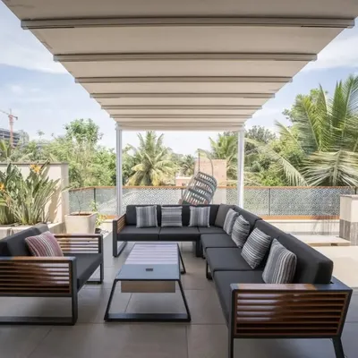 This expansive terrace is designed for gathering. The large, comfortable sectional sofa under a retractable awning creates a perfect outdoor living room for family and friends to mingle and enjoy the view.