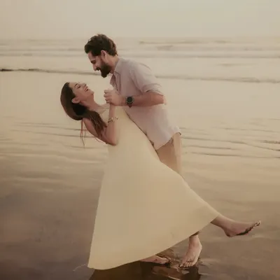 A playful dip and a shared laugh on the wet sand. I love capturing these spontaneous, joyful moments during a pre-wedding beach shoot.