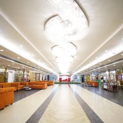 The grand hall of the wedding venue, showing the magnificent chandeliers and spacious layout. Capturing the venue helps set the scene for the entire event.