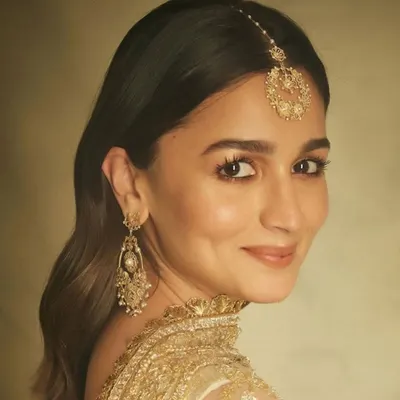 A beautiful shot of Alia Bhatt, her smile radiating warmth. She is wearing my handcrafted 18k gold filigree earrings and a matching maang tika, pieces designed to feel both traditional and timeless.