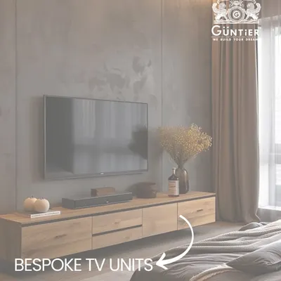 A bespoke wooden TV unit that combines open shelving and concealed storage, creating a functional and stylish focal point in the bedroom.