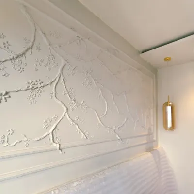 The finished cherry blossom mural, created for a young student's bedroom. The entire piece is painted in a single, subtle tone to blend with the wall, creating a serene and sophisticated sanctuary that feels both personal and timeless.