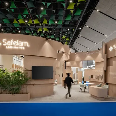 The entrance to the Safelam Laminates pavilion was designed to be open and inviting, with layered curvilinear walls creating a sense of depth. The strategic placement of bamboo and a large screen balances the natural and digital elements of the brand story.