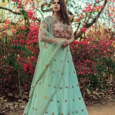 A model in a beautiful mint green lehenga with a contrasting pink blouse. The delicate embroidery makes this a fresh and elegant choice for a daytime wedding function or a sangeet.