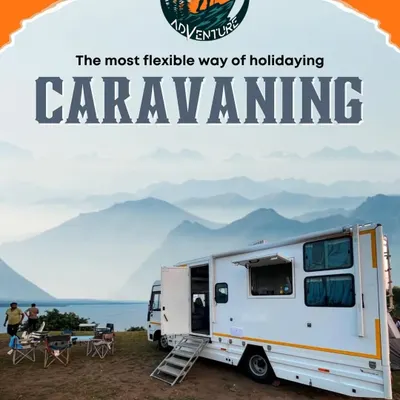 Our caravan parked by the water, with the side awning extended to create a perfect outdoor living space. This is your base for adventure, wherever you decide to stop.