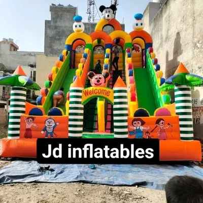 This is our 4-slider bouncy castle, measuring 18x26 feet. It features a central climbing area and four separate slides, topped with Mickey and Donald Duck characters.
