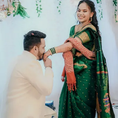 A beautiful moment of chivalry and tradition during an engagement ceremony. The groom kissing the bride's hand is a timeless gesture of love and respect, captured here with her joyful smile.