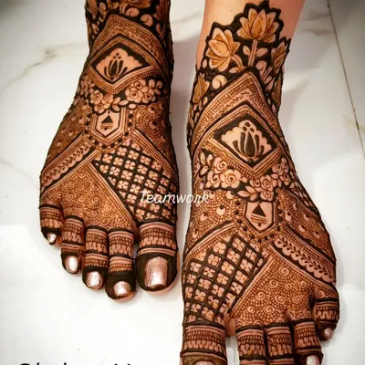 A classic bridal foot design featuring lotus motifs and a heavy jaal (net) pattern. The symmetry and clean lines are key to this look.