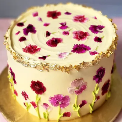 Sometimes less is more. This elegant cake is decorated with pressed edible flowers and a touch of gold leaf for a simple, natural beauty.
