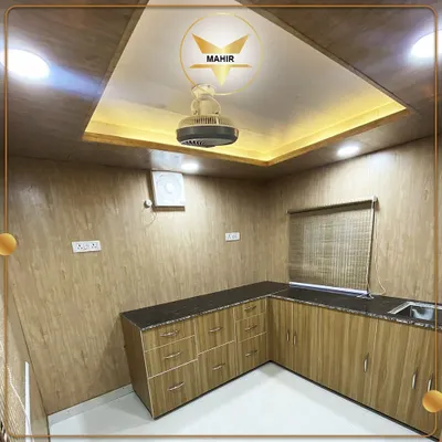 This is the pantry and kitchen area inside a 40-foot container that also houses an office, bedroom, and drawing room. We design and build multi-functional spaces with all necessary amenities, including custom cabinetry and modern electrical fixtures.