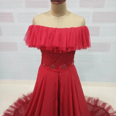 A close-up of our red off-the-shoulder gown, featuring a ruffled tulle neckline and an embellished waistband. This style is a fantastic rental option for maternity shoots or pre-wedding photos.