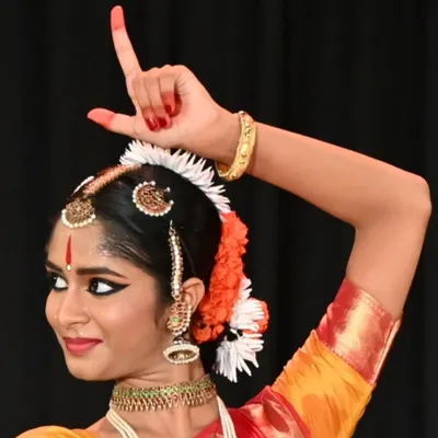 A student's arangetram is a reflection of the teacher's work. This image captures the grace and confidence of my shishya Anvita Jain, showcasing the intricate hand gestures or mudras that are fundamental to Bharatanatyam storytelling.