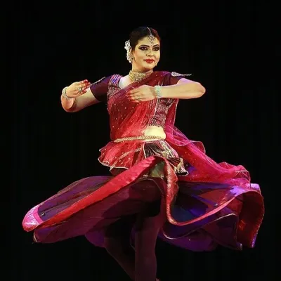 A senior artist demonstrates the dynamic 'chakkar' or spin, a hallmark of Kathak dance. Our advanced classes focus on perfecting such techniques with speed, grace, and precision.