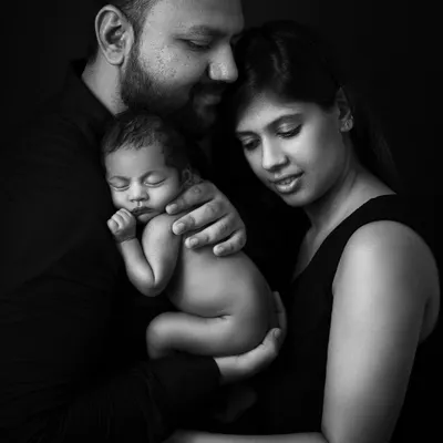 A family's love, captured in dramatic low-key lighting. Black and white photography strips away everything but the emotion, creating a powerful and eternal memory.