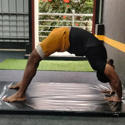 Flexibility is a journey, not a destination. This student is working on his backbend, or wheel pose, to improve spinal mobility and strength.