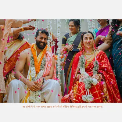A beautiful moment from a South Indian wedding ceremony, capturing the couple's joy as they are showered with blessings and petals by their families.