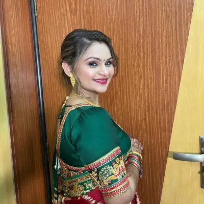 A beautiful client ready for a wedding. Her makeup is elegant and sophisticated, with a classic red and green saree.