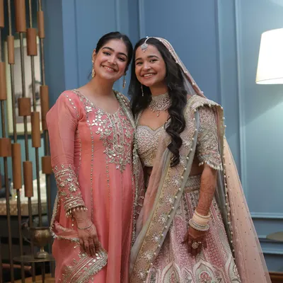 A beautiful moment with a bride I styled. I'm wearing a peach suit with mirror work, a great option for a wedding guest attending a day function, while the bride looks radiant in her pastel lehenga.