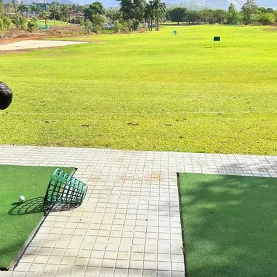 A young student at our academy focuses on his shot at the driving range. We believe in starting early to instill good habits and a passion for the sport.