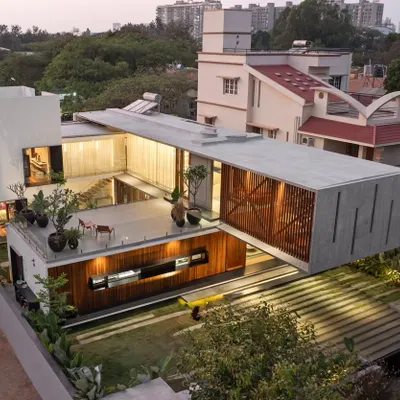 An aerial view of the Long House at twilight, highlighting the dramatic 24-foot cantilever. This structural feat allows the upper volume to hover, creating a dynamic composition of intersecting horizontal and vertical planes.