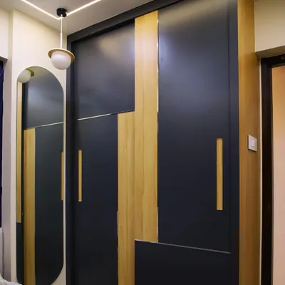 A modern sliding wardrobe with a striking geometric pattern of dark laminate and wood finish, combining bold design with practical storage.