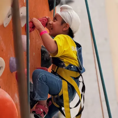 The smile says it all! A young climber in his harness beams with excitement, ready to take on the wall. We believe in building confidence through fun and safe challenges.