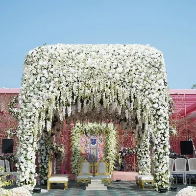 Our ‘Ivory Paradise’ mandap is a vision of pure elegance, fully covered in thousands of white flowers and cascading wisteria. This design creates a serene and absolutely breathtaking focal point for the ceremony.