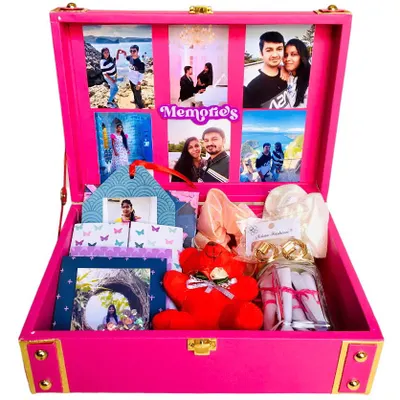 A birthday gift that holds a lifetime of memories. This beautiful pink trunk hamper opens to reveal a collage of 18 photos, along with scrunchies, earrings, a teddy, and a jar of "reasons why I love you" notes.